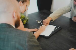 Signature d'une promesse d'achat au Québec par un couple devant un courtier