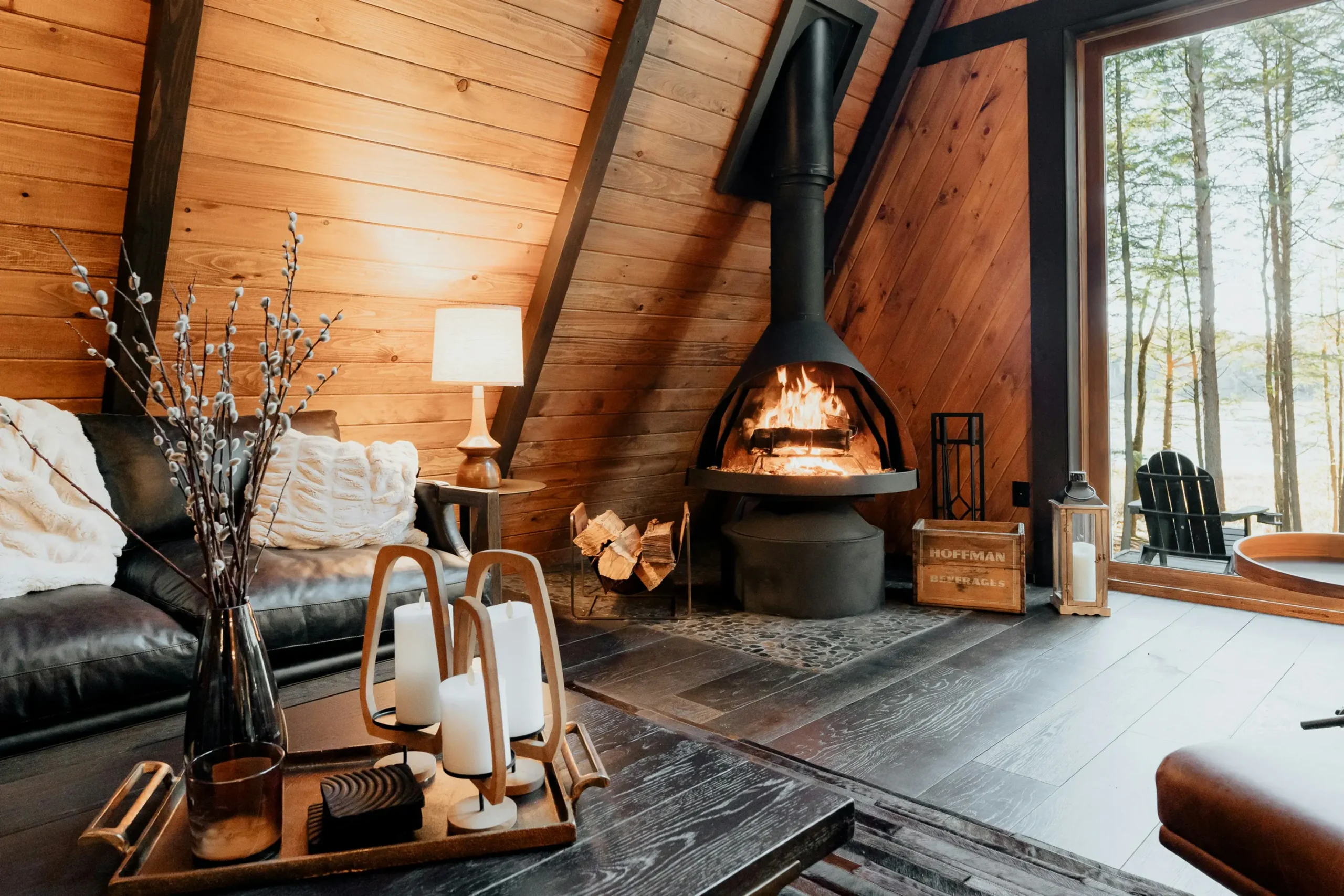 Intérieur chaleureux d'un chalet quatre saisons avec poêle à bois et grandes fenêtres
